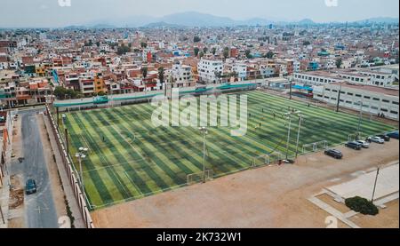 Luftaufnahme des Fußballfeldes in der Mitte eines chaotischen Viertels, Callao, Lima. Peru Stockfoto