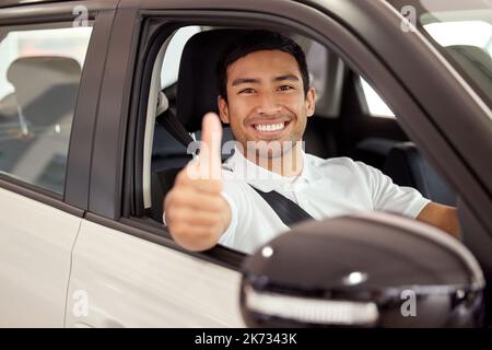 Sichere Reisen. Ein Mann zeigt Daumen nach oben, während er in seinem neuen Auto sitzt. Stockfoto