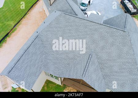 Da dieses Haus gebaut wird, wird das Dach des neu gebauten Hauses mit Asphaltschindeln bedeckt Stockfoto