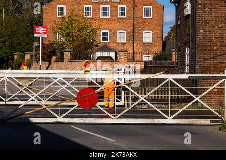 Bahnübergangstore, die von der Wache auf dem alten manuellen Bahnübergang in Heckington Village, Lincolnshire, England, geschlossen wurden. Stockfoto