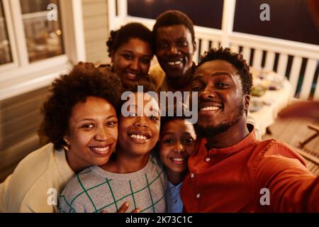 POV der glücklichen afroamerikanischen Familie, die am Abend Selfie-Fotos auf der Terrasse des Hauses macht Stockfoto