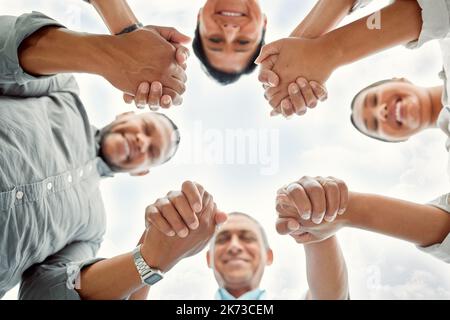 Die Dinge, die wichtig sind, sind Glaube, Familie und Freunde. Eine Familie in einem Huddle draußen. Stockfoto