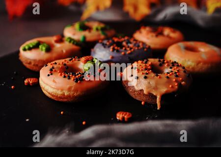 Hausgemachte Mini-Herbst-Donuts mit orangefarbenem Zuckerguss, selektivem Focu Stockfoto
