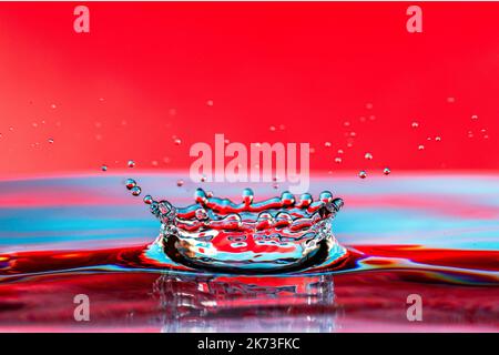 Farbenfrohe Wassertropfen spritzen auf die Oberfläche. Stockfoto