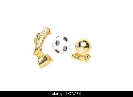 Ein Bild von goldenen Stiefeln, goldenem Ball und Fußball auf weißem Hintergrund. Stockfoto