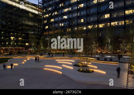 Abendlicher Weitblick über den Platz mit der Stadt im Hintergrund. Exchange Square, London, Großbritannien. Architekt: DSDHA, 2022. Stockfoto