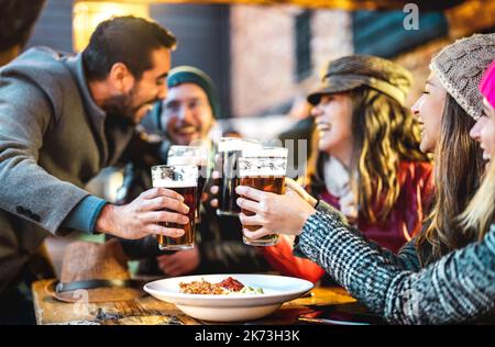 Fröhliche Menschen trinken Bier in der Brauerei Bar Out Side - Getränke Lifestyle-Konzept mit Jungs und Mädchen genießen Winterzeit zusammen Stockfoto