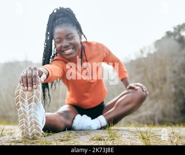 Stretching ist mein Lieblingsteil beim Training. Ganzkörperaufnahme einer jungen Frau, die vor dem Training im Freien sitzt und sich dehnt. Stockfoto