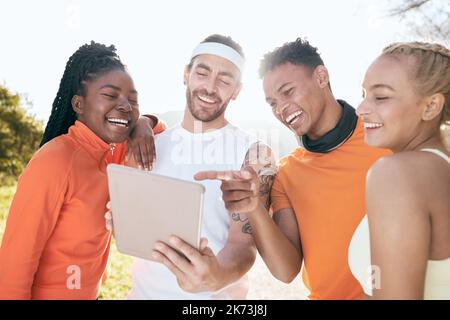 Das ist unser Tagesziel. Eine vielfältige Gruppe von Freunden, die während ihres Outdoor-Workouts zusammen stehen und ein digitales Tablet verwenden. Stockfoto
