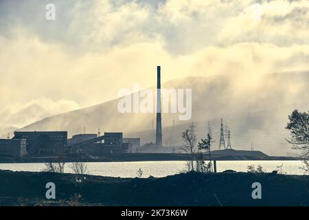 Industrielandschaft mit starker Verschmutzung durch eine große Fabrik. Rohre auf dem Gebiet der Anlage.