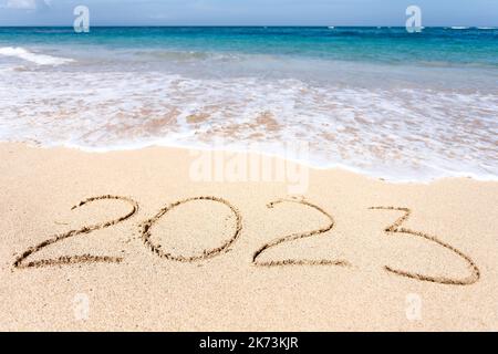 Neujahr 2023, Schriftzug am Strand mit Welle Stockfoto