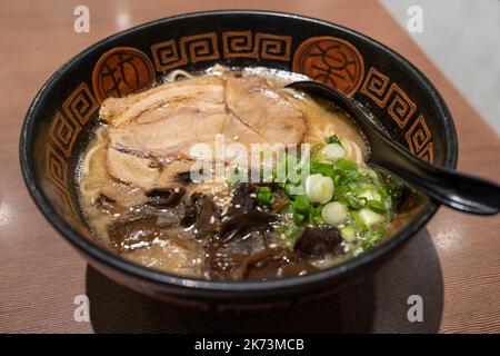 Nahaufnahme der japanischen Ramen-Suppe mit Huhn, Schnittlauch und Pilz auf dem Holztisch. Stockfoto