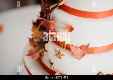 Herbstlicher Hochzeitstorte, bedeckt mit süßen Herbstblättern Stockfoto