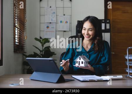 Junge Frau Immobilienberater im Gespräch mit Kunden online über Haus verkaufen oder kaufen Konzept. Stockfoto