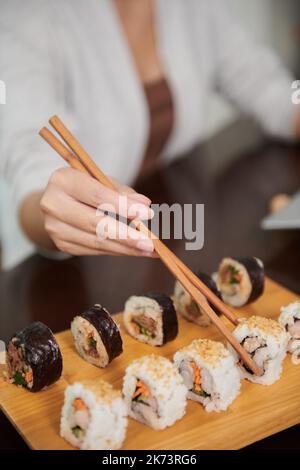 Nahaufnahme der Frau, die leckeres Sushi zum Mittagessen im Restaurant isst Stockfoto