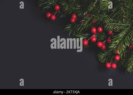 Weihnachten Grenze mit frischen Tannenzweigen und roten Beeren auf schwarzem Papier Hintergrund angeordnet, kopieren Platz für Text Stockfoto