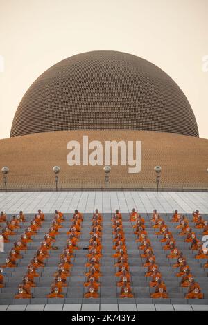 Buddhistische Mönche beten während einer jährlichen Zeremonie am 11. Februar 2017 im Wat Phra Dhammakaya Tempel im Norden von Bangkok, Thailand. Die Thailänder feiern das buddhistische Fest der Umkreisung im Uhrzeigersinn und der Makha pratipa-Laternen-Beleuchtungszeremonie im Dhammakaya-Tempel am „Makha Bucha Day“ während des dritten Mondmondes, bei dem sich rund 1250 Mönche versammelten, um vom Buddha ordiniert zu werden. Stockfoto