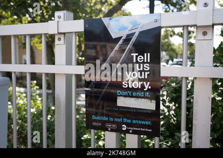 Farmingdale, New York, USA. 21. September 2022. Eine Selbstmordhotline und ein Schild zur Selbstmordprävention, das versucht, Menschen davon abzuhalten, auf die Gleise vor sich bewegenden Zügen am Bahnhof Farmingdale im Landkreis Nassau zu springen, Die Long Island Rail Road ist das verkehrsreichste Bahnnetz der westlichen Hemimisphaire, aber die MTA steht vor einer erheblichen Finanzkrise, nachdem die COVID-19-Pandemie die Fahrwerkszahlen mit Heimarbeit und Telearbeit angedrosselt hatte Immer mehr, und die Umsätze im Bereich der Tarebox werden drastisch gemein. (Cr Stockfoto