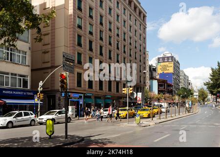 Blick auf Menschen, die eine der Hauptstraßen namens Halaskargazi im Stadtteil Sisli in Istanbul überqueren. Es ist ein sonniger Sommertag. Stockfoto