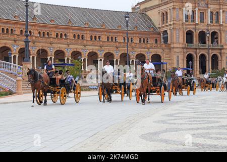 SEVILLA, SPANIEN - 21. MAI 2017: Es gibt eine retro-Pferdekutschen mit Touristen auf einer Tour durch den Spanien-Platz. Stockfoto