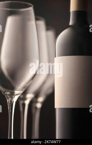 Schöne Flasche Rotwein drei Gläser close-up Fragment vertikalen Foto. Eine weiße leere Beschriftung für den Kopierbereich. Stockfoto