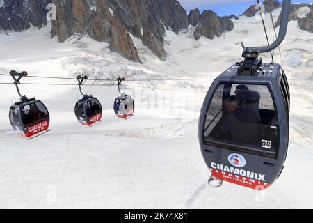 Vom Gipfel der Aiguille aus ist es möglich, den Punkt Helbronner in Italien mit dem Panorama Mont-Blanc zu erreichen. Die Gondeln fliegen vorbei, das Tal Blanche der Gletscher des Riesen. Stockfoto