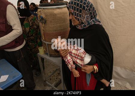 Juillet 2017 - Syrie - Rojava - Syrie du Nord - Camp de deplaces d'Ain Issa / Clinique MSF / Une mere et son bebe attendent leur Tour Stockfoto