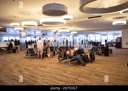 SeaTac, Washington, USA. 30. September 2022. Fluggäste, die am S-Gates von SeaTac auf ihre Flüge warten.die Luftfahrtindustrie hat nach den Pandemieausfällen der COVID-19 erhebliche Probleme mit sich gebracht, da die meisten Fluggesellschaften ihre Mitarbeiter nur entlassen haben, um die Flugreisen schnell wieder anzukurieren. Piloten, Flugbegleiter und allgemeiner Personalmangel haben im Jahr 2022 Zehntausende von Flugausfällen in den Vereinigten Staaten verursacht. (Bild: © Taidgh Barron/ZUMA Press Wire) Stockfoto