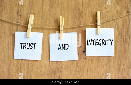 Symbol für Vertrauen und Integrität. Konzeptwörter Vertrauen und Integrität auf White Papers auf Holzklättchen. Schöner Holzhintergrund. Geschäft und Vertrauen ein Stockfoto