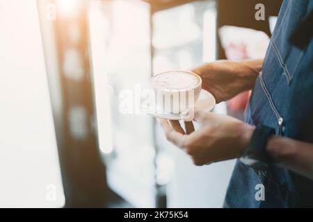 Asiatischer Barista, der Kaffee für die Gäste zubereitet Stockfoto