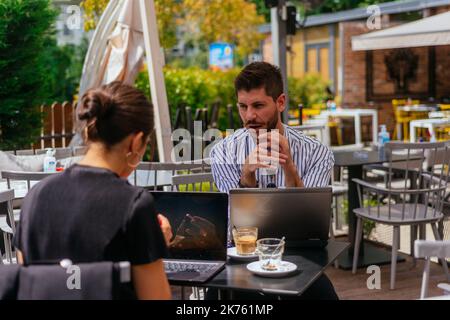 Das Geschäftspaar hat an einem sonnigen Tag Spaß, nachdem es das Problem eines Projekts erfolgreich gelöst hat Stockfoto