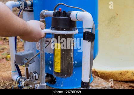 Der Austausch der austauschbaren Filter wird von einem professionellen Mitarbeiter für die Reinigung von Wasser im Außenbereich des Hauses durchgeführt Stockfoto