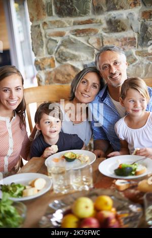 Es ist immer besser, wenn sie zusammen waren. Ein Porträt einer glücklichen, generationenübergreifenden Familie, die zu Hause zu Mittag gegessen hat. Stockfoto