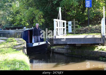 Ein enges Boot fährt über eine Schaukelbrücke auf dem Peak Forest Canal in der Nähe von Disley, Heshire Stockfoto