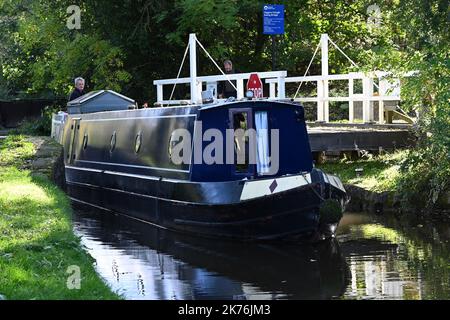 Ein enges Boot fährt über eine Schaukelbrücke auf dem Peak Forest Canal in der Nähe von Disley, Heshire Stockfoto