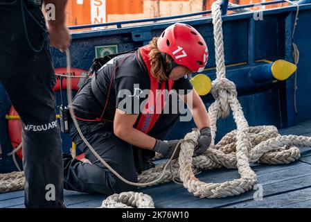 Burriana, Spanien. 17. Oktober 2022. Eine Seemannin des SMH-Rettungsteams nimmt das Cape an Bord, um die ersten offenen Seerettungsübungen des Schiffes Aita Mari zu absolvieren. Das spanische NGO-SMH-Team verlegt das Schiff Aita Mari für die ersten Rettungsübungen auf offener See und bereitet sich auf die neunte Rettungsmission mit afrikanischen Flüchtlingen vor, die in Booten über das Mittelmeer nach Europa einschiffen. Kredit: SOPA Images Limited/Alamy Live Nachrichten Stockfoto