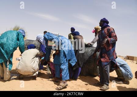 Dorfbewohner aus Koygouma (Kreis Goundam, Gemeinde Gargando) in der Region Timbuktu kommen, um Wasser aus einer Zisterne zu holen. Nach Angaben einiger Bewohner würden die Tanks in Goundam etwa 50km von Koygouma aus gefüllt werden, bevor sie in das Dorf transportiert werden. Der Zugang zu Trinkwasser ist heute eines der wichtigsten Probleme für die Bevölkerung dieser Wüstengebiete, die mit einer erheblichen Wasserknappheit konfrontiert sind, während im vergangenen April 2086 malische Flüchtlinge aus dem Mbera-Lager in Mauretanien in ihr Dorf zurückgeführt wurden. Stockfoto