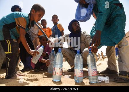 Dorfbewohner aus Koygouma (Kreis Goundam, Gemeinde Gargando) in der Region Timbuktu kommen, um Wasser aus einer Zisterne zu holen. Nach Angaben einiger Bewohner würden die Tanks in Goundam etwa 50km von Koygouma aus gefüllt werden, bevor sie in das Dorf transportiert werden. Der Zugang zu Trinkwasser ist heute eines der wichtigsten Probleme für die Bevölkerung dieser Wüstengebiete, die mit einer erheblichen Wasserknappheit konfrontiert sind, während im vergangenen April 2086 malische Flüchtlinge aus dem Mbera-Lager in Mauretanien in ihr Dorf zurückgeführt wurden. Stockfoto