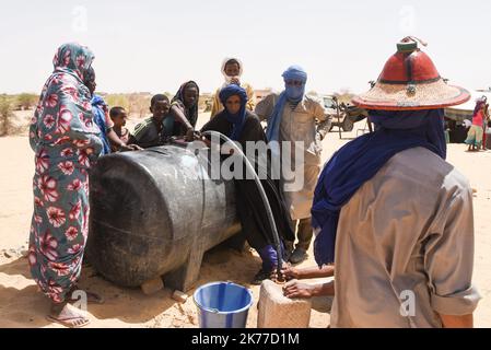 Dorfbewohner aus Koygouma (Kreis Goundam, Gemeinde Gargando) in der Region Timbuktu kommen, um Wasser aus einer Zisterne zu holen. Nach Angaben einiger Bewohner würden die Tanks in Goundam etwa 50km von Koygouma aus gefüllt werden, bevor sie in das Dorf transportiert werden. Der Zugang zu Trinkwasser ist heute eines der wichtigsten Probleme für die Bevölkerung dieser Wüstengebiete, die mit einer erheblichen Wasserknappheit konfrontiert sind, während im vergangenen April 2086 malische Flüchtlinge aus dem Mbera-Lager in Mauretanien in ihr Dorf zurückgeführt wurden. Stockfoto