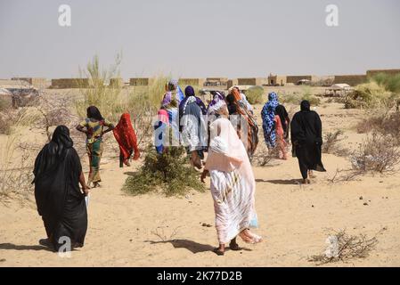 Eine Gruppe von Frauen und Kindern zieht in das Dorf Koygouma. Im Dorf Koygouma (Bezirk Goundam, Gemeinde Gargando) in der Region Timbuktu wurden im April 2086 malische Flüchtlinge aus dem Lager Mbera in Mauretanien zurückgeführt. 2013 mussten sie aus dem Konflikt fliehen. Ihre Rückführung wurde durch den mauretanischen UNHCR und den UNHCR in Mali mit der Regierung und ihren Partnern erleichtert. Am 6. Mai 2019 besuchte eine Delegation des UNHCR und der MINUSMA in Begleitung des Gouverneurs der Region Koina AG Ahmadou Koygouma. Stockfoto