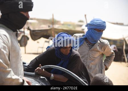 Dorfbewohner aus Koygouma (Kreis Goundam, Gemeinde Gargando) in der Region Timbuktu kommen, um Wasser aus einer Zisterne zu holen. Nach Angaben einiger Bewohner würden die Tanks in Goundam etwa 50km von Koygouma aus gefüllt werden, bevor sie in das Dorf transportiert werden. Der Zugang zu Trinkwasser ist heute eines der wichtigsten Probleme für die Bevölkerung dieser Wüstengebiete, die mit einer erheblichen Wasserknappheit konfrontiert sind, während im vergangenen April 2086 malische Flüchtlinge aus dem Mbera-Lager in Mauretanien in ihr Dorf zurückgeführt wurden. Stockfoto