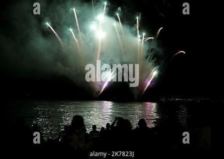 Am Vorabend des Bastille-Tages, am 13. Juli 2019, neben der Promenade des Anglais in Nizza, sitzen die Menschen am Strand, um ein Feuerwerk am Himmel zu sehen Stockfoto