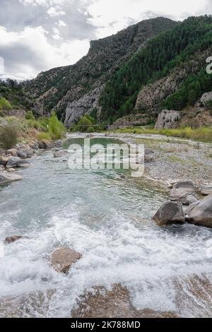 aqua blau klares Bergflußwasser fließt durch eine steinerne Schlucht Stockfoto