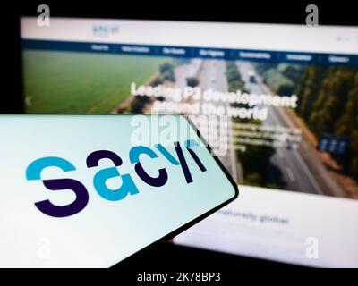 Smartphone mit Logo des spanischen Infrastrukturunternehmens Sacyr S.A. auf dem Bildschirm vor der Business-Website. Konzentrieren Sie sich auf die Mitte rechts des Telefondisplays. Stockfoto