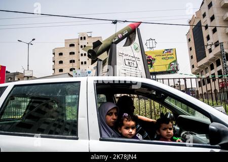 ©Michael Bunel / Le Pictorium/MAXPPP - Michael Bunel / Le Pictorium - 5/11/2018 - Palästina / Bande de Gaza / Gaza-Stadt - Une famille dans une voiture passe devant un rond-Point surplombe d'une Statue representant un rakete aux couleurs de la Palestine. Il est ecrit dessus que Al-qassam, Branche Armee du Hamas bombardera Israel. 10 Mai 2018. Gaza. Palästina. / 5/11/2018 - Palästina / Gaza-Streifen / Gaza-Stadt - Eine Familie im Auto fährt an einem Kreisverkehr vorbei, der mit einer Statue überhängt ist, die eine Rakete in den Farben Palästinas darstellt. Es steht geschrieben, dass Al-Qassam, der bewaffnete Flügel der Hamas, ISR bombardieren wird Stockfoto