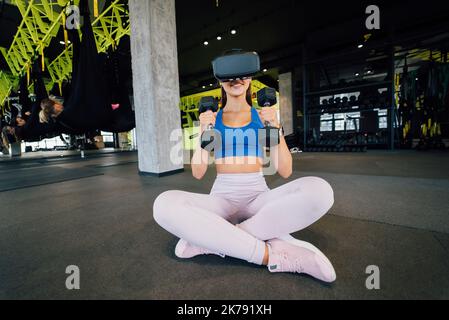 Frau trägt Brille der virtuellen Realität Training mit Hanteln Stockfoto