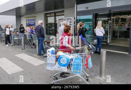 Ängstlich stürmten die Portugiesen die Supermärkte, um Grundbedürfnisse zu kaufen und Vorräte zu erhalten. Hier in Albufeira an der Algarve beginnen sich die Leute vor einem Lidl-Laden anzustellen, der einen Hausmeister eingerichtet hat und nur wenige Kunden auf einmal einlässt. Stockfoto