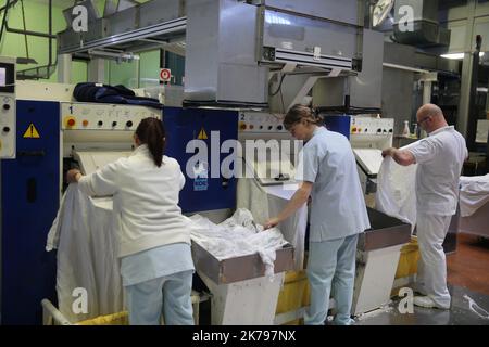 Mitarbeiter, die Wäsche in der Wäscherei des Krankenhauses Emile Muller in Mulhouse verarbeiten Stockfoto