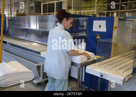 Mitarbeiter, die Wäsche in der Wäscherei des Krankenhauses Emile Muller in Mulhouse verarbeiten Stockfoto