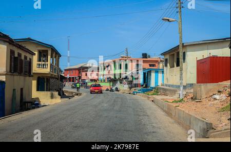 Cape Coast, Ghana - 14. April 2022: Typische Afrikanische Straße mit bunten Gebäuden in der Nähe der lokalen Kapstadt in Ghana Stockfoto